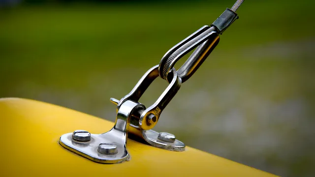 Close-up of stainless steel rigging and yellow surface, emphasizing durability. LOLER and work at height duties for exhibition stand builds