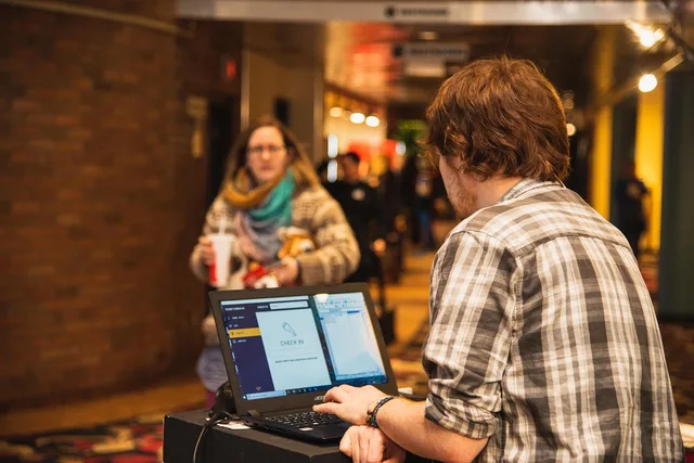 indoors, movie theatre, ticket, ticket check-in, customer, lobby, theatre, movie, computer, scanner, brown computer, brown laptop, brown movie, brown theater, brown check, ticket, lobby, lobby, scanner, scanner, scanner, scanner, scanner. How to run ethical and compliant trade show marketing